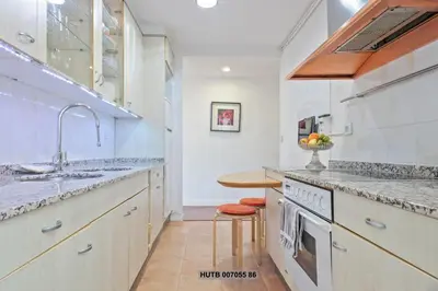a kitchen with white cabinets and a sink and a counter at Alcam Augusta in Barcelona