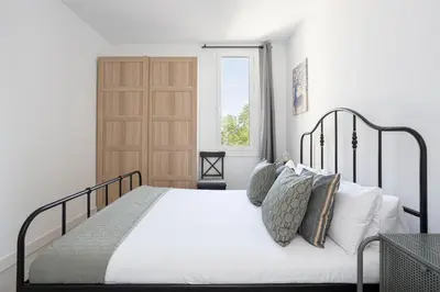 a bedroom with a bed with white sheets and pillows at Bright & Stylish Flat In Trendy Grcia in Barcelona