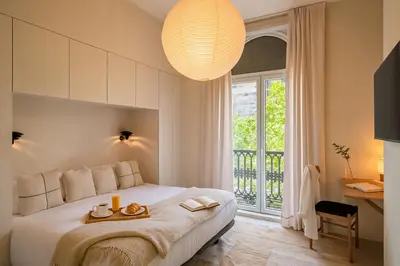 a bedroom with a large white bed with a window at The Boulevard by Aspasios in Barcelona
