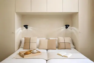 a white bed with a tray and books on it at The Boulevard by Aspasios in Barcelona