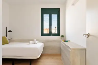 a white room with a bed and a window at OLA LIVING - MT - Aire 1 in Barcelona