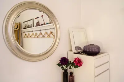 a mirror on a wall next to a vase with flowers at Housalia Ondina Suites Sagrada Familia in Barcelona