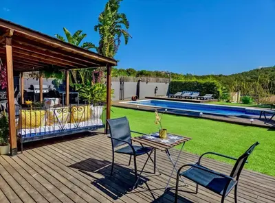 a deck with a table and chairs and a pool at Villa Barcelona Experience Penedes Sitges Bliss with Private Pool in Can Trabal