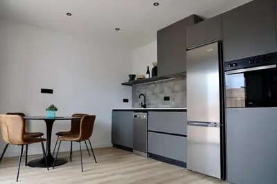 a kitchen with a table and a refrigerator at Quiet Apartment in Sitges Center Steps from Beach in Sitges