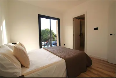 a bedroom with a large bed with a large window at Quiet Apartment in Sitges Center Steps from Beach in Sitges