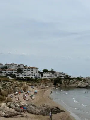 a group of people on a beach near the water at Quiet Apartment in Sitges Center Steps from Beach in Sitges