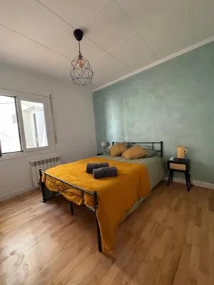 a bedroom with a bed with a yellow blanket on it at Vila Viva Mundo in San Cipriano de Vallalta
