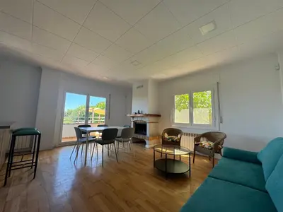 a living room with a couch and a table and chairs at Vila Viva Mundo in San Cipriano de Vallalta