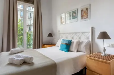 a bedroom with a large white bed with towels on it at Urgell in Barcelona