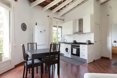 a kitchen with a table and chairs and a refrigerator at Urgell in Barcelona