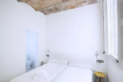 a white room with a bed and a window at yök Casa Cultura in Barcelona