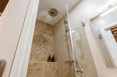 a shower with a glass door in a bathroom at Lodging Apartments Almirall Beach 12 in Barcelona