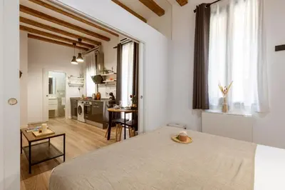 a kitchen and living room with a table in a room at Lodging Apartments Almirall Beach 12 in Barcelona
