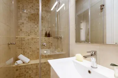 a bathroom with a sink and a shower with a mirror at Lodging Apartments Almirall Beach 12 in Barcelona