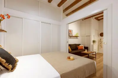 a bedroom with a bed and a living room at Lodging Apartments Almirall Beach 12 in Barcelona