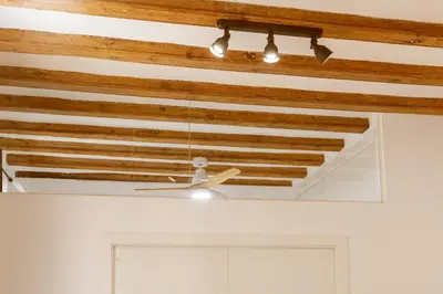 a ceiling fan hanging from a wooden ceiling at Lodging Apartments Almirall Beach 12 in Barcelona