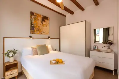 a bedroom with a large white bed with fruit on it at Lodging Apartments Almirall Beach 42 in Barcelona