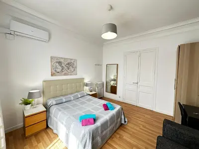 a bedroom with two beds and a desk with a television at Gran Via Rooms in Barcelona