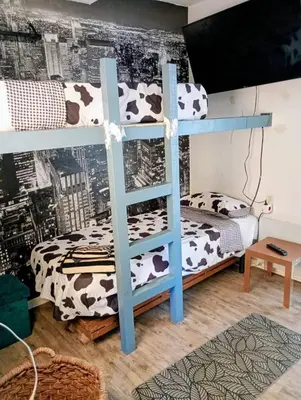 a bunk bed in a room with a cow print wall at Frente al mar con Terraza - Sitges in Sitges