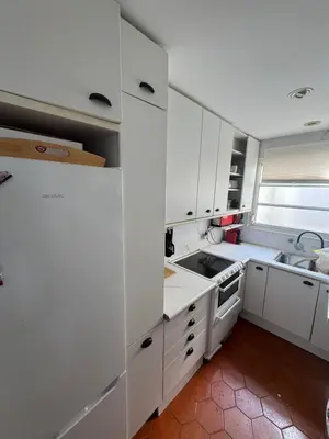 a kitchen with white cabinets and a sink at Frente al mar con Terraza - Sitges in Sitges