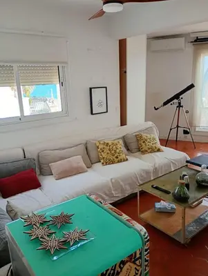 a living room with a white couch and a table at Frente al mar con Terraza - Sitges in Sitges