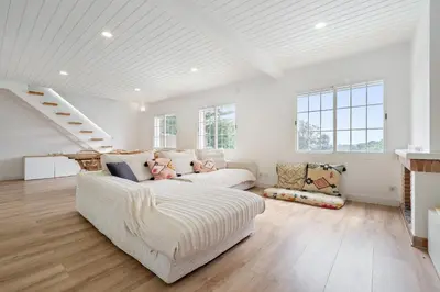 a white bedroom with a bed and a window at Hauzify I Casa Montjuïc in Sant Cebrià de Vallalta