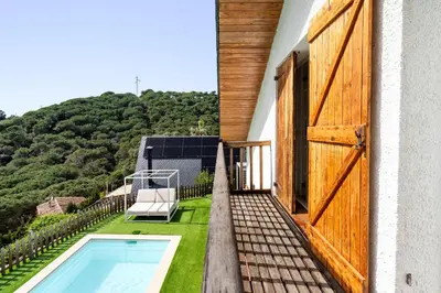 a bathroom with a sink and a washing machine at Hauzify I Casa Montjuïc in Sant Cebrià de Vallalta