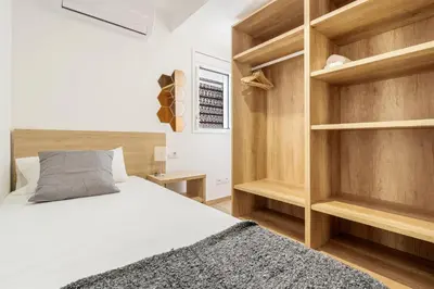 a bedroom with a bed and wooden shelves at 4182 - AB Poble Sec - Plaza España X in Barcelona