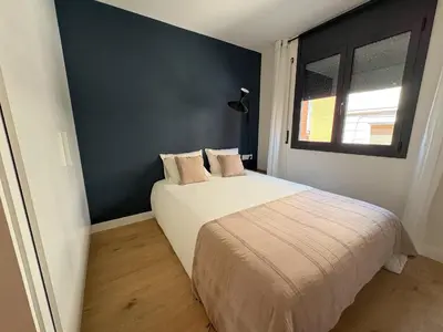a bedroom with a bed and a blue wall at Stay U-nique Apartments at Albigesos in Barcelona
