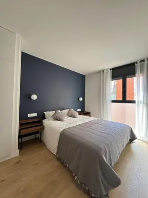a bedroom with a large bed with a blue wall at Stay U-nique Apartments at Albigesos in Barcelona