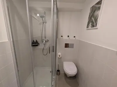a white bathroom with a shower and a toilet at Barcelona Touch Apartments - Font Honrada in Barcelona