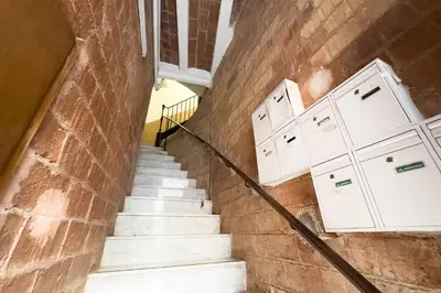 a stairway with white cabinets on a brick wall at Barcelona Touch Apartments - Fontrodona in Barcelona