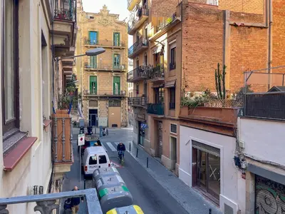 a man walking down a city street with buildings at Barcelona Touch Apartments - Fontrodona in Barcelona