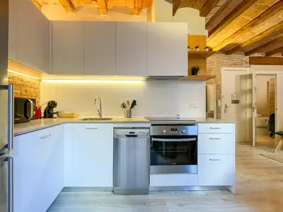 a kitchen with white cabinets and a stainless steel oven at Barcelona Touch Apartments - Fontrodona in Barcelona