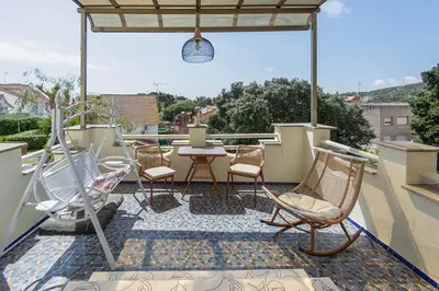 a patio with chairs and a table on a roof at Can cruspinera WITH 6BEEDROOM in Tiana