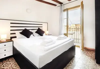 a bedroom with a large white bed and a balcony at Catalan Charm 3BR w 15 Baths in Barcelona