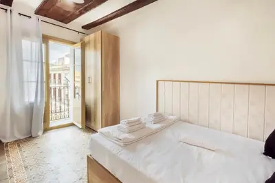 a bedroom with a white bed and a large window at Catalan Charm 3BR w 15 Baths in Barcelona