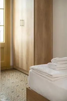 a bedroom with a bed and a closet with white sheets at Catalan Charm 3BR w 15 Baths in Barcelona
