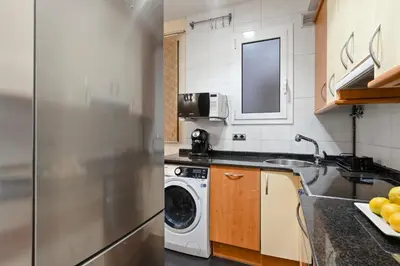 a kitchen with a refrigerator and a washing machine at Steps to Sagrada Família AC Elevator in Barcelona