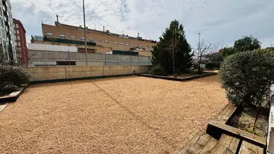 a large dirt yard with a building in the background at Apartamento independiente con jardín in Terrassa