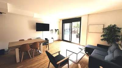 a living room with a table and a couch at Apartamento independiente con jardín in Terrassa