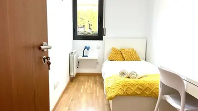 a small bedroom with a bed and a window at Apartamento independiente con jardín in Terrassa