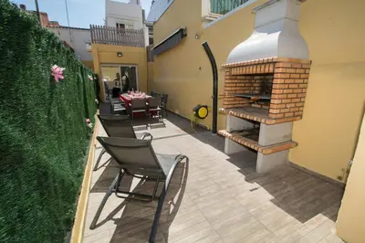 a patio with a fireplace and a table and chairs at Casa con piscina en el centro de Calella, Aire in Calella