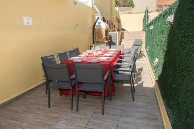 a table with a red tablecloth and chairs on a patio at Casa con piscina en el centro de Calella, Aire in Calella