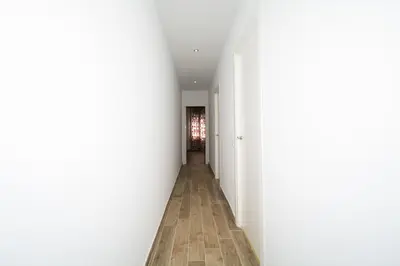 an empty hallway with white walls and wooden floors at Casa con piscina en el centro de Calella, Aire in Calella