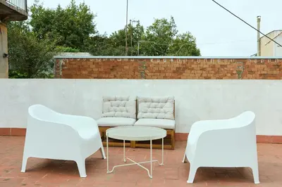 two white chairs and a table and a couch at Park Guell in Barcelona