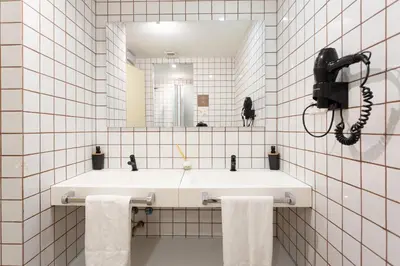 a white bathroom with a sink and a mirror at GG Hostel in Barcelona