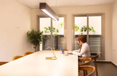 a woman sitting at a table with a laptop at GG Hostel in Barcelona