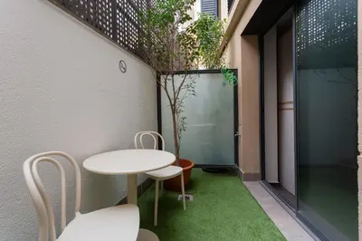 a small garden with a table and chairs in a building at GG Hostel in Barcelona