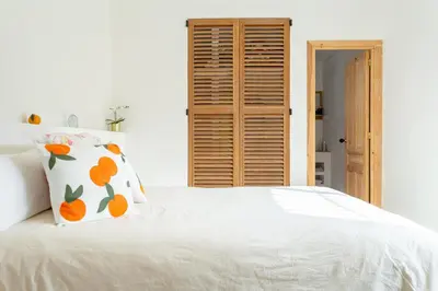 a bedroom with a white bed with an orange pillow at Ibiza style villa with swimming pool near Sitges in Cunit